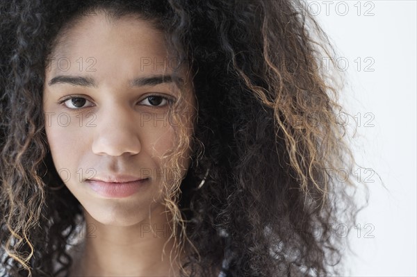 Portrait of teenage girl (16-17) on white background.