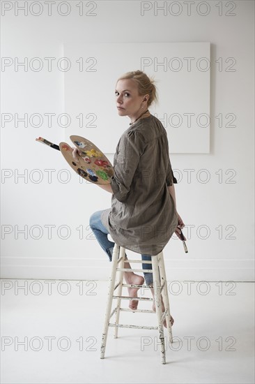 Female artist painting in studio.