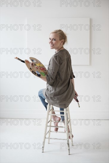 Female artist painting in studio.