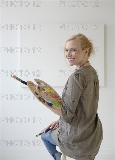 Female artist painting in studio.