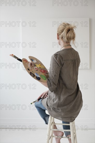 Female artist painting in studio.