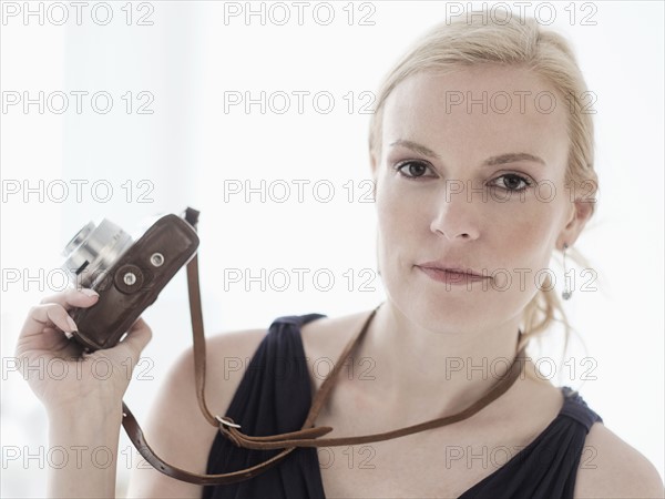 Woman holding digital camera.