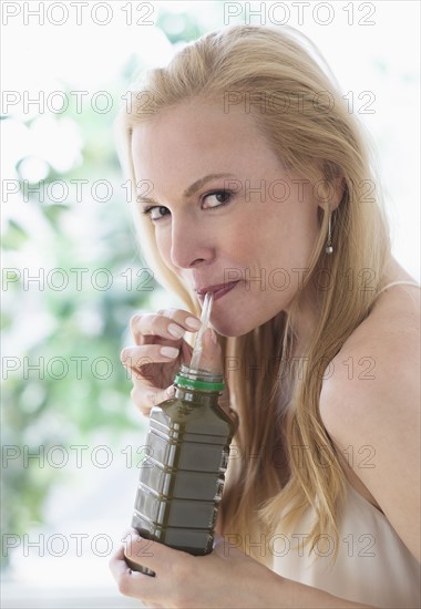 Woman drinking from bottle.