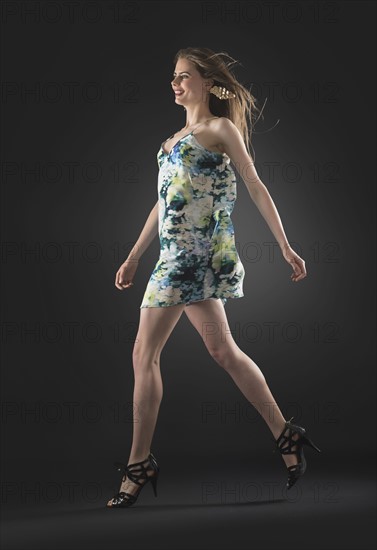 Studio shot of young woman walking.