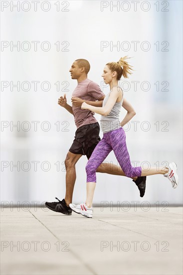 Mid adult couple running.