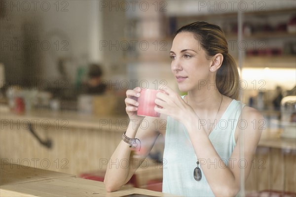 Woman holding coffee cup in cafe.