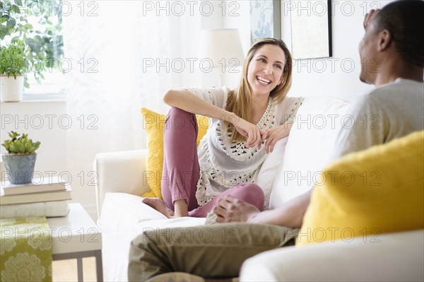 Mid adult couple relaxing in living room.