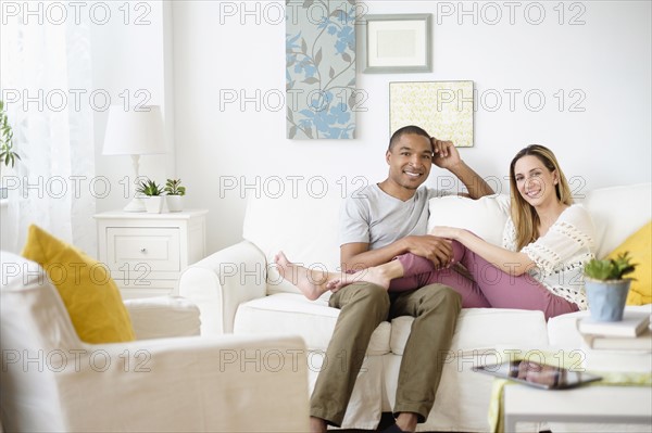 Mid adult couple relaxing in living room.