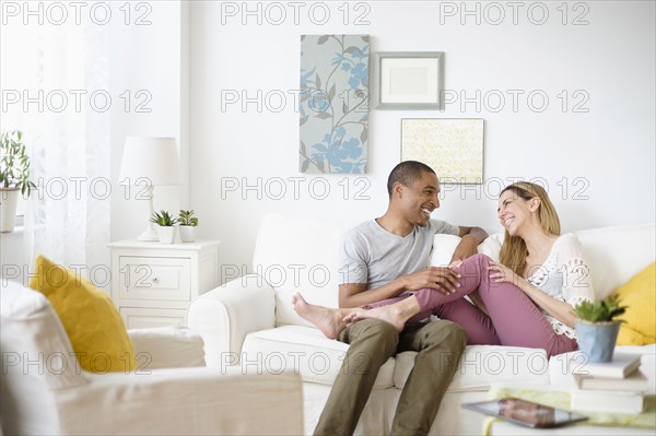 Mid adult couple relaxing in living room.