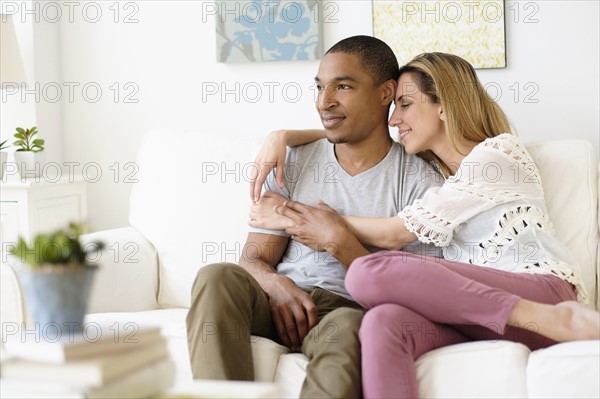 Mid adult couple embracing in living room.