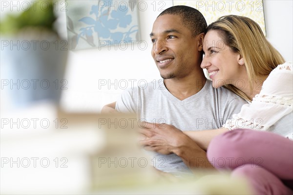 Mid adult couple embracing in living room.