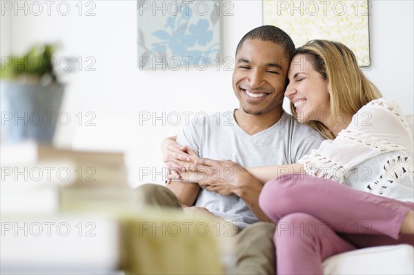 Mid adult couple embracing in living room.