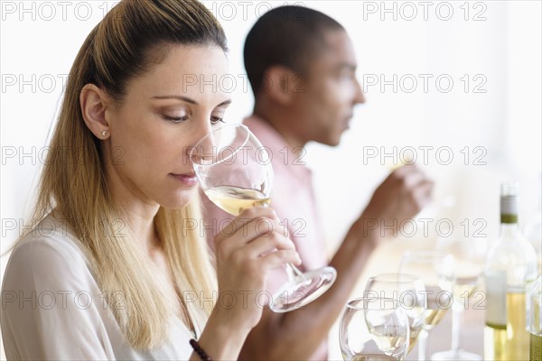 Man and woman tasting white wine.