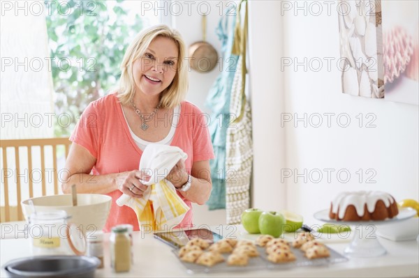 Mature woman baking in kitchen.