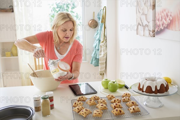 Mature woman baking in kitchen.