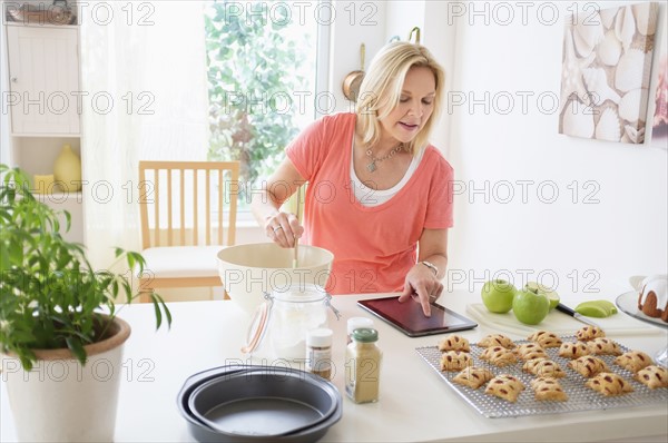Mature woman baking in kitchen.