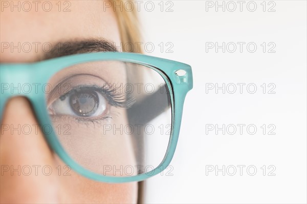 Portrait of young woman wearing eyeglasses in studio.