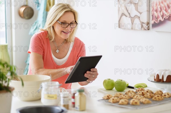 Mature woman baking in kitchen.