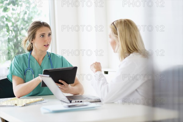 Two female doctors talking in office.