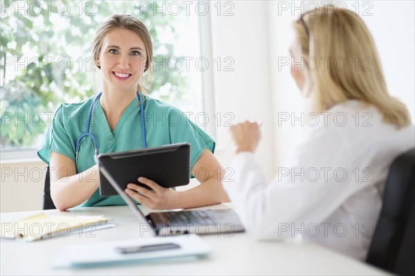 Two female doctors talking in office.