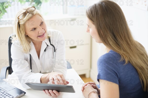 Doctor talking to patient in office.