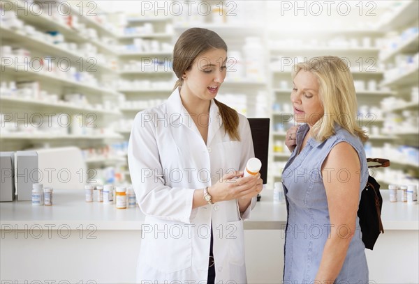 Patient talking to pharmacist in pharmacy.