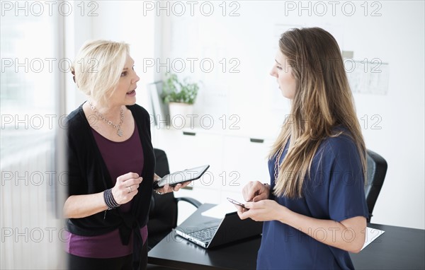 Two women talking in office.