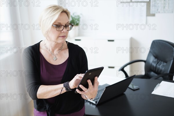 Businesswoman using tablet in office.