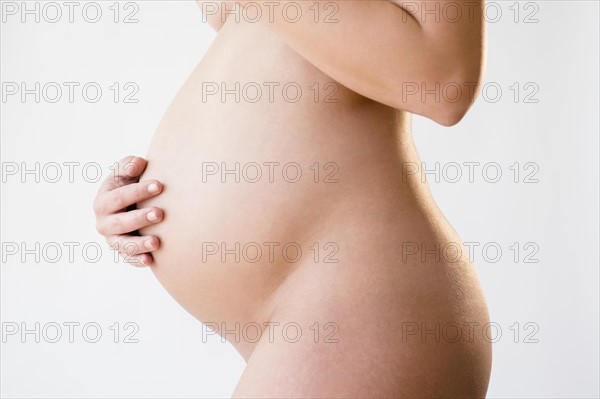 Studio shot of naked, pregnant woman