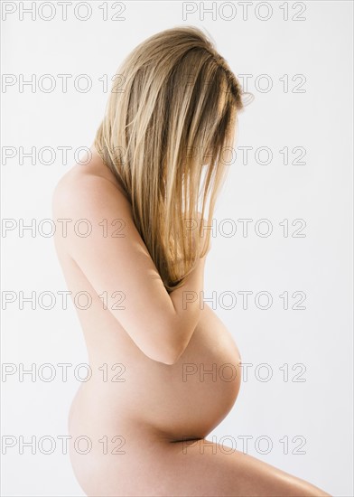 Studio shot of naked, pregnant woman