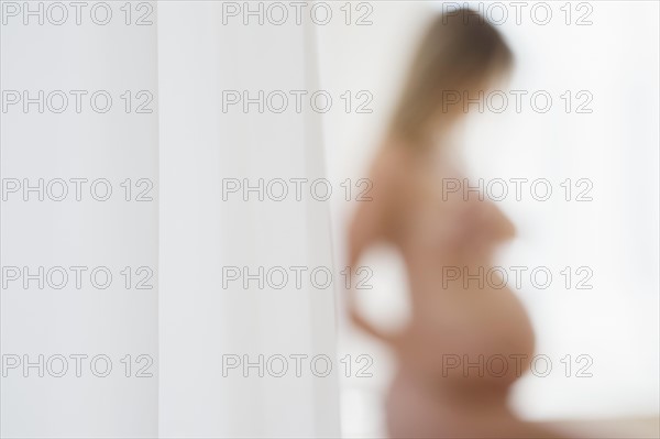 Defocused image of naked pregnant woman