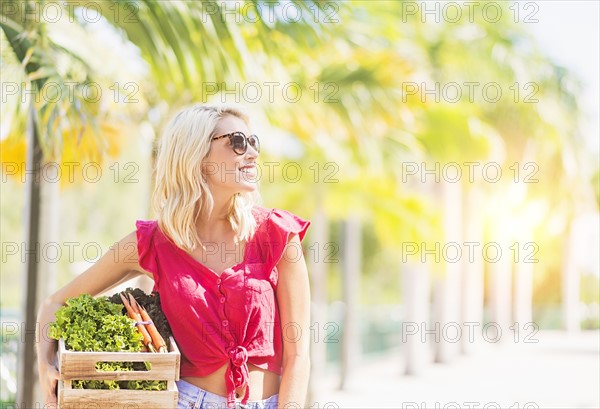 Woman carrying box with vegetables