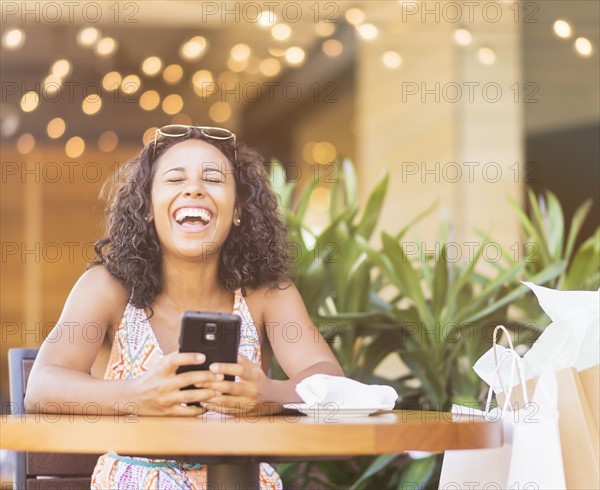 Woman using phone in cafe