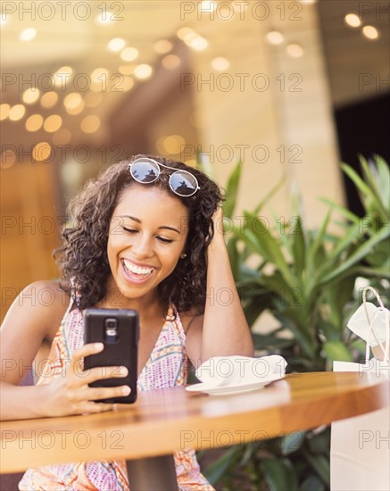 Woman using phone in cafe