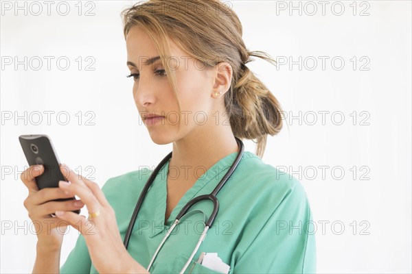 Young female doctor using smart phone.