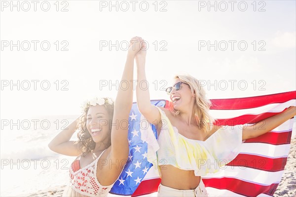 Female friends on beach with American flag