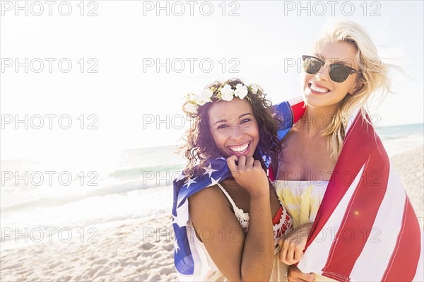 Female friends on beach with American flag