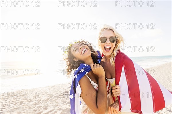 Female friends on beach with American flag