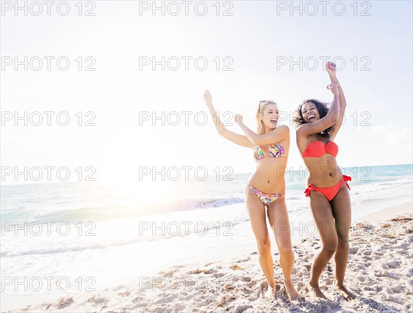 Female friends dancing on beach