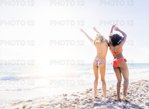 Female friends dancing on beach