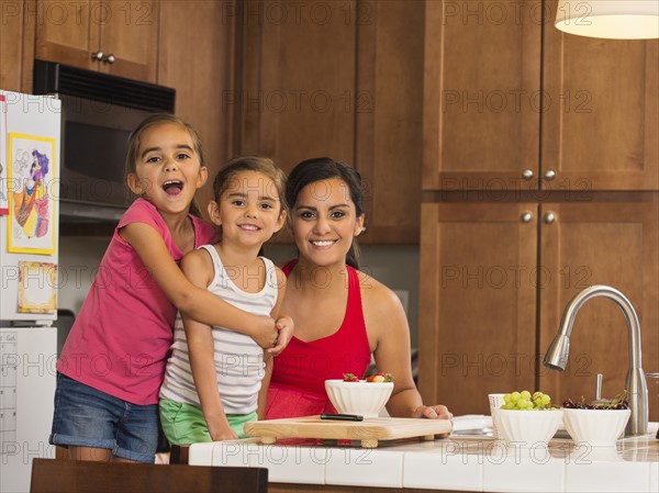 Mother and children (6-7, 8-9) preparing food in kitchen
