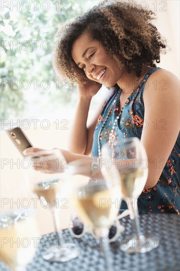 Young woman using smart phone at restaurant.