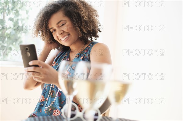 Young woman using smart phone at restaurant.