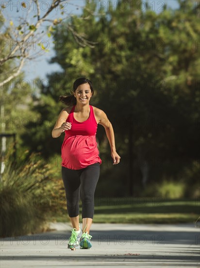 Pregnant woman running outdoors