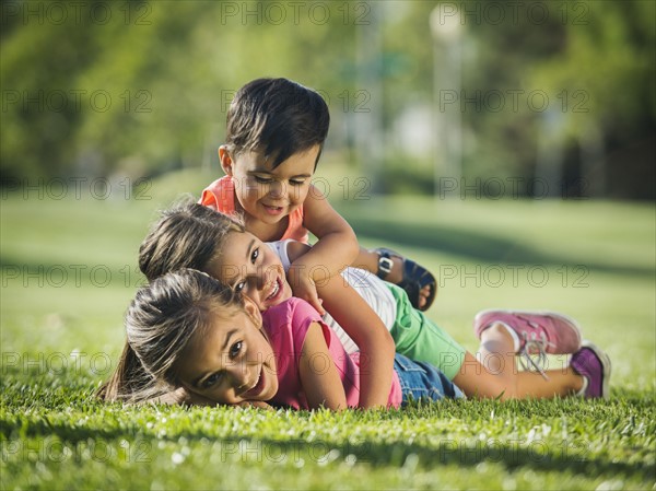 Children (2-3, 6-7, 8-9) playing in park