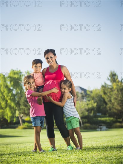 Pregnant mother and children (2-3, 6-7, 8-9) in park