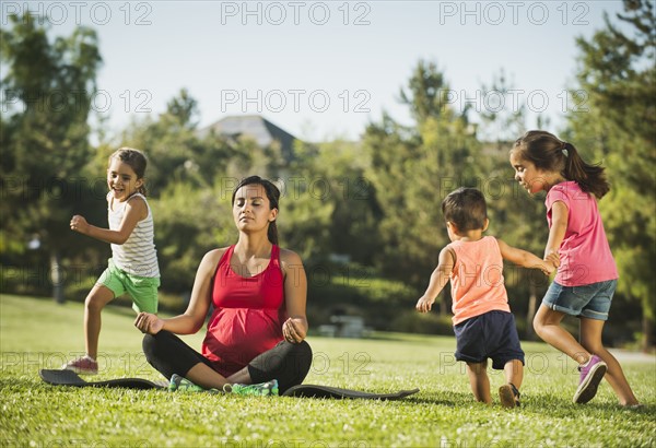 Pregnant mother and children (2-3, 6-7, 8-9) in park