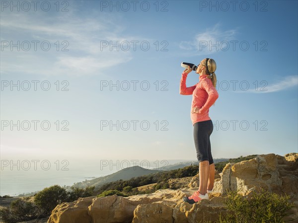 Woman in sportswear drinking water