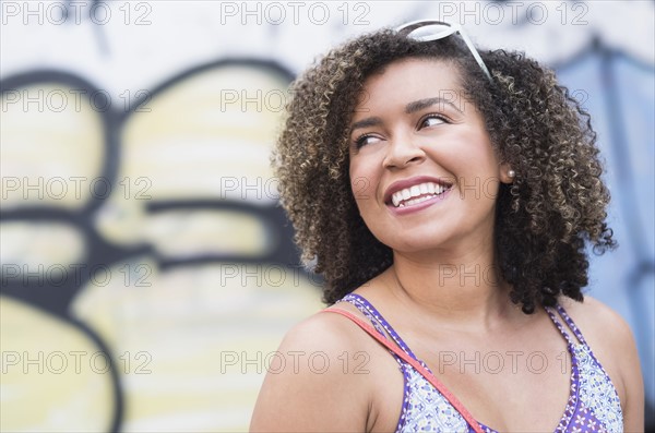 Portrait of smiling young woman with curly hair.