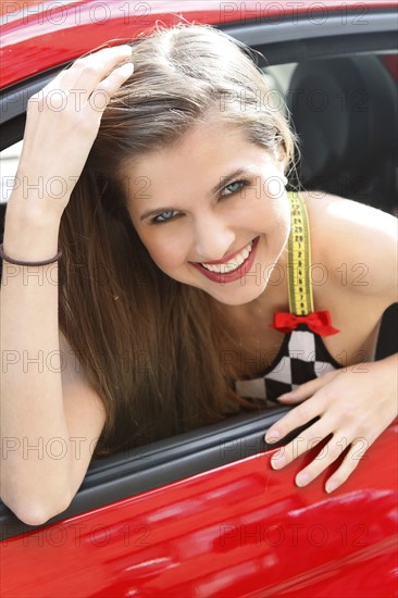 Portrait of smiling woman in red car